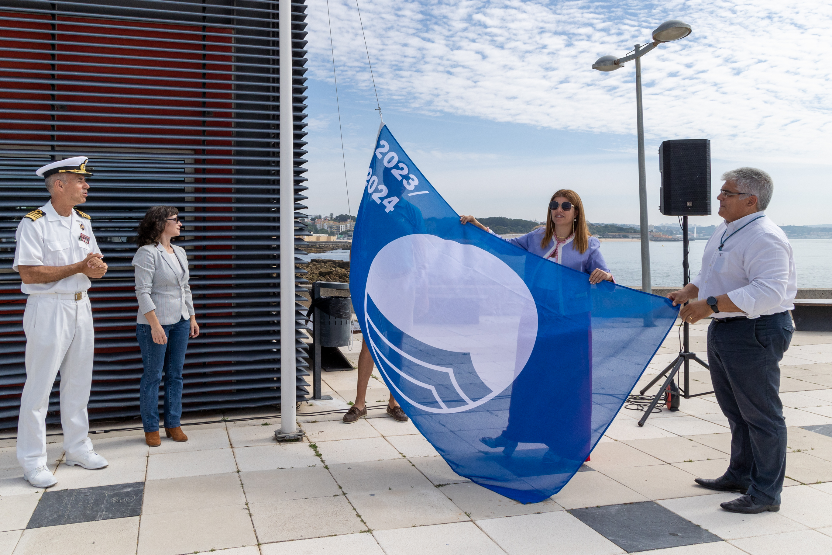 Vereadora Joana Baptista segurando a bandeira azul