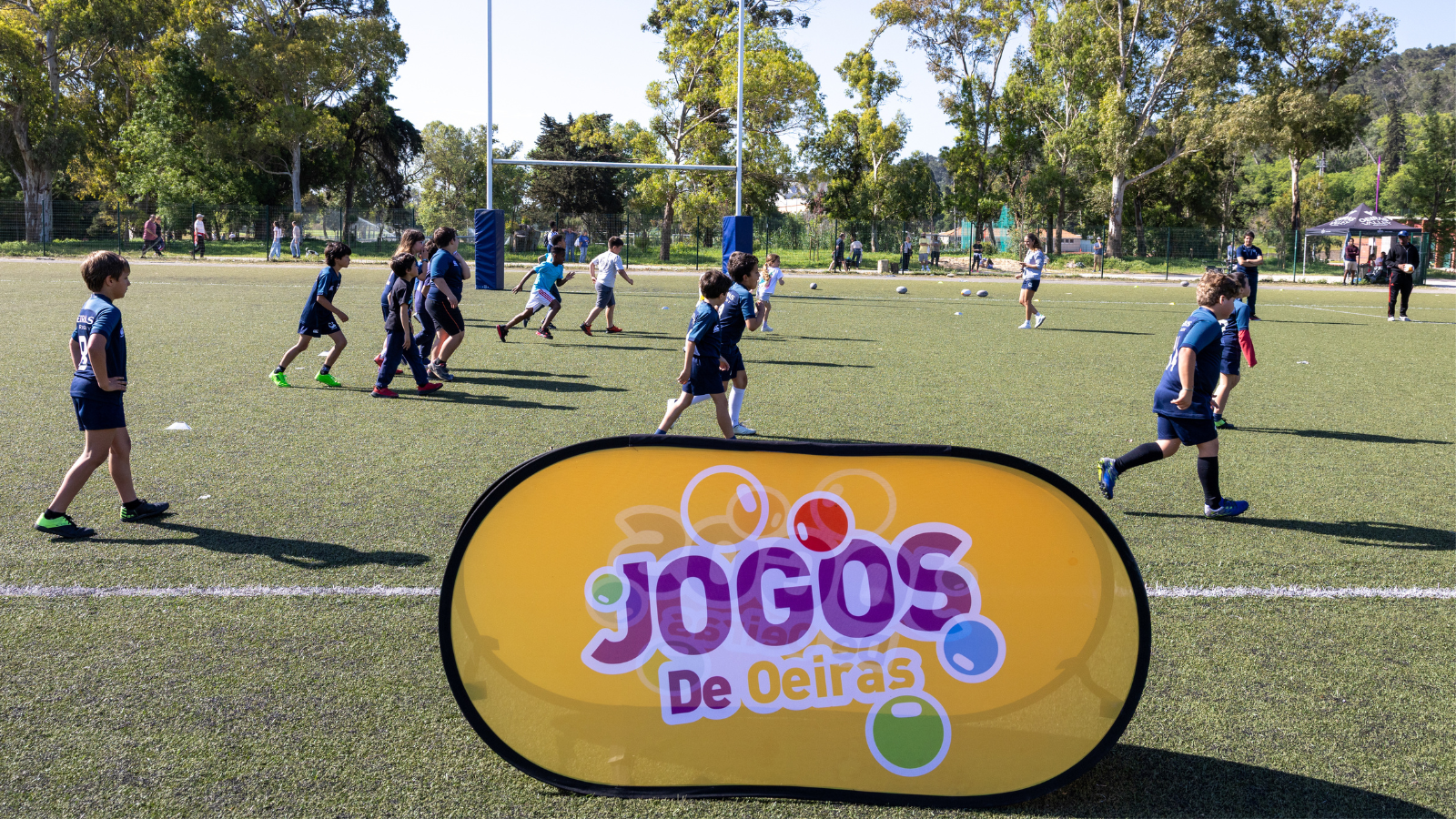crianças a correr no campo de rugby do jamor